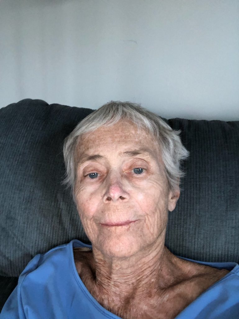 gray haired woman in blue shirt with slight smile